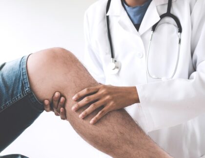 doctor checking patient with knees to determine the cause of illness t20 bx3XX9