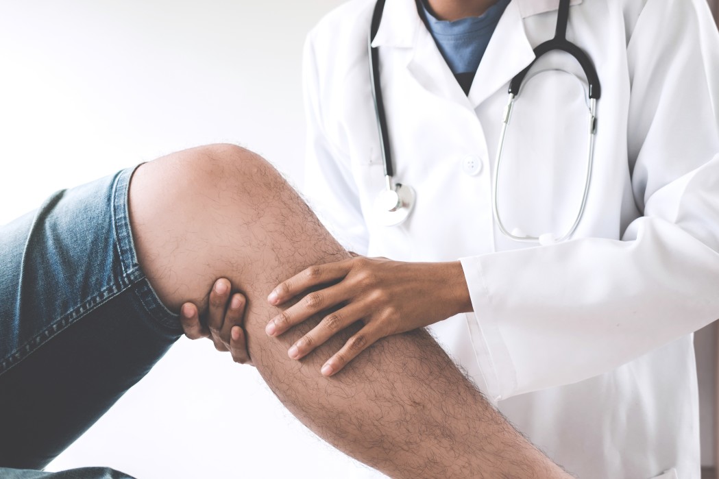 doctor checking patient with knees to determine the cause of illness t20 bx3XX9